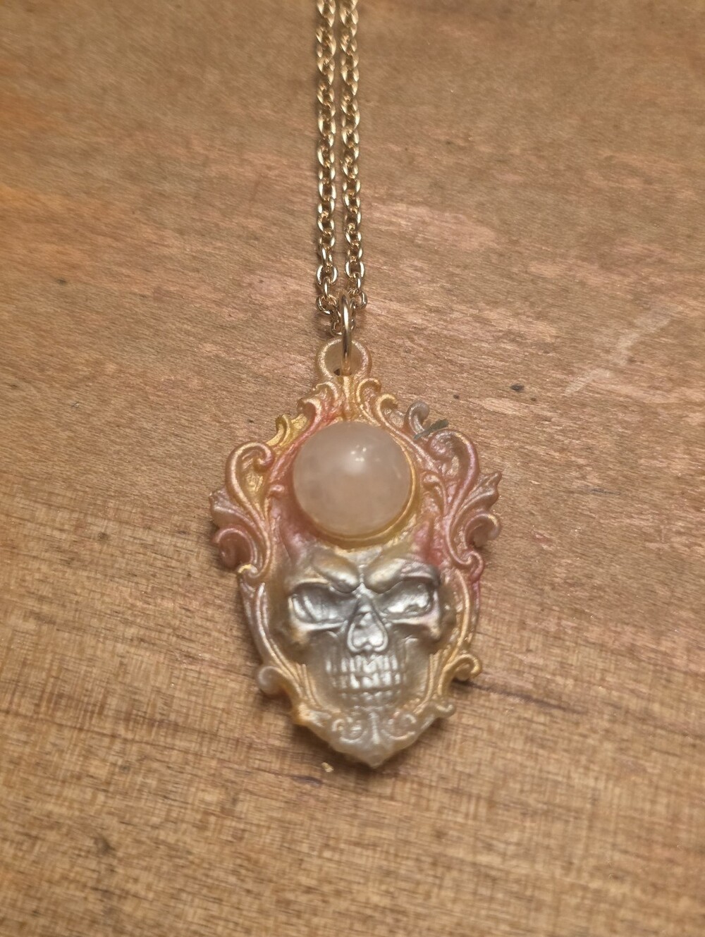 Flaming Goth Skull Woth Pink Central Gemstone On A Gold Tone Chain Necklace